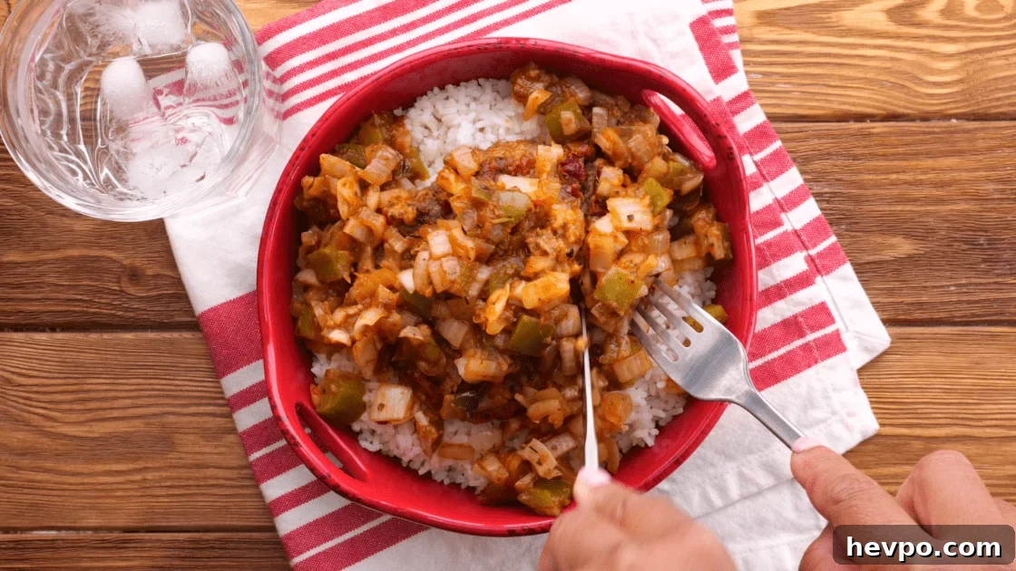 Hamburger patties with gravy and rice.