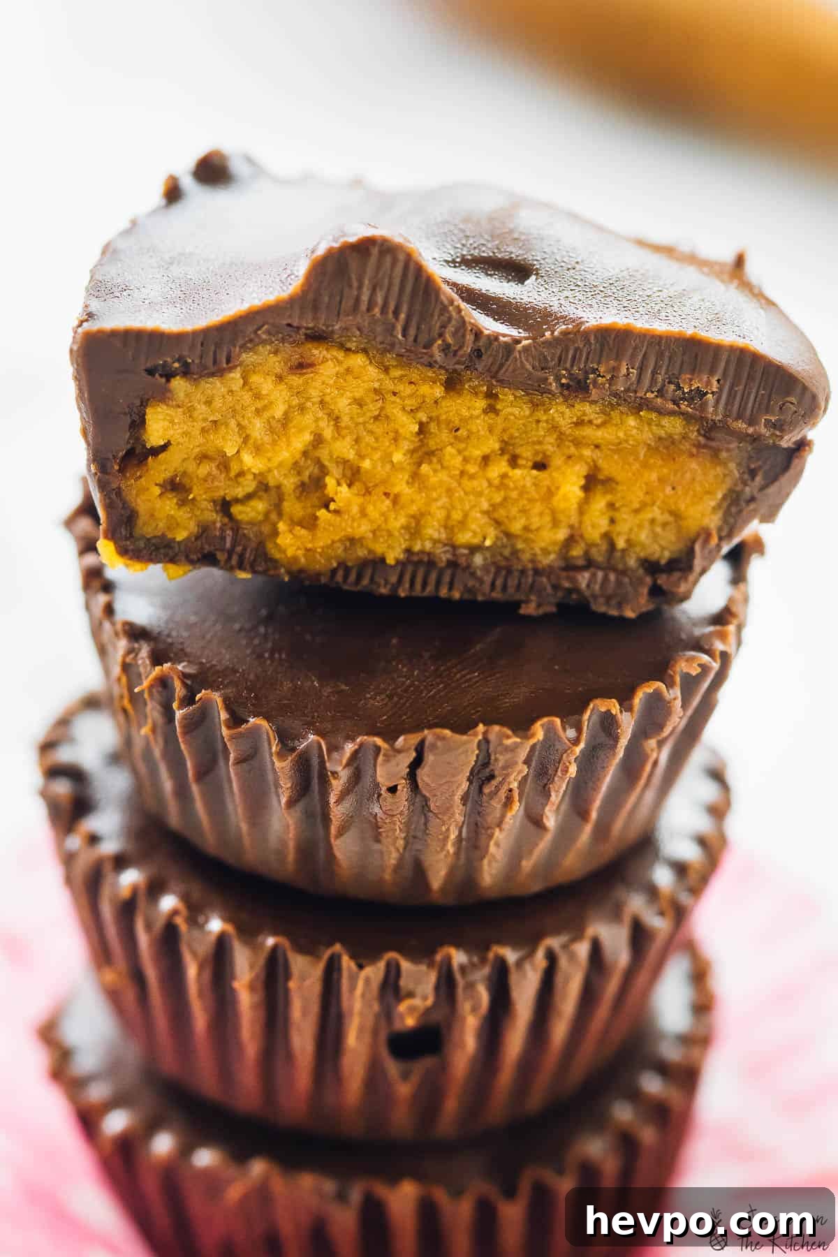Close of a stack of pumpkin chocolate cups.