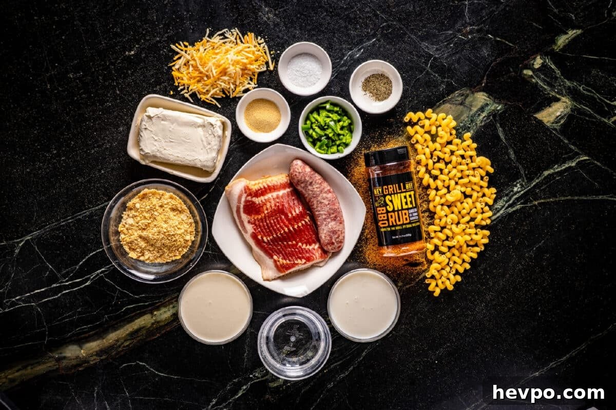 Jalapeno Popper Mac and Cheese Recipe An overhead shot of a white plate with raw bacon and sausage, a bottle of Hey Grill Hey Sweet Rub, loose corn kernels and shredded cheese, and several bowls of raw ingredients on a marble surface.