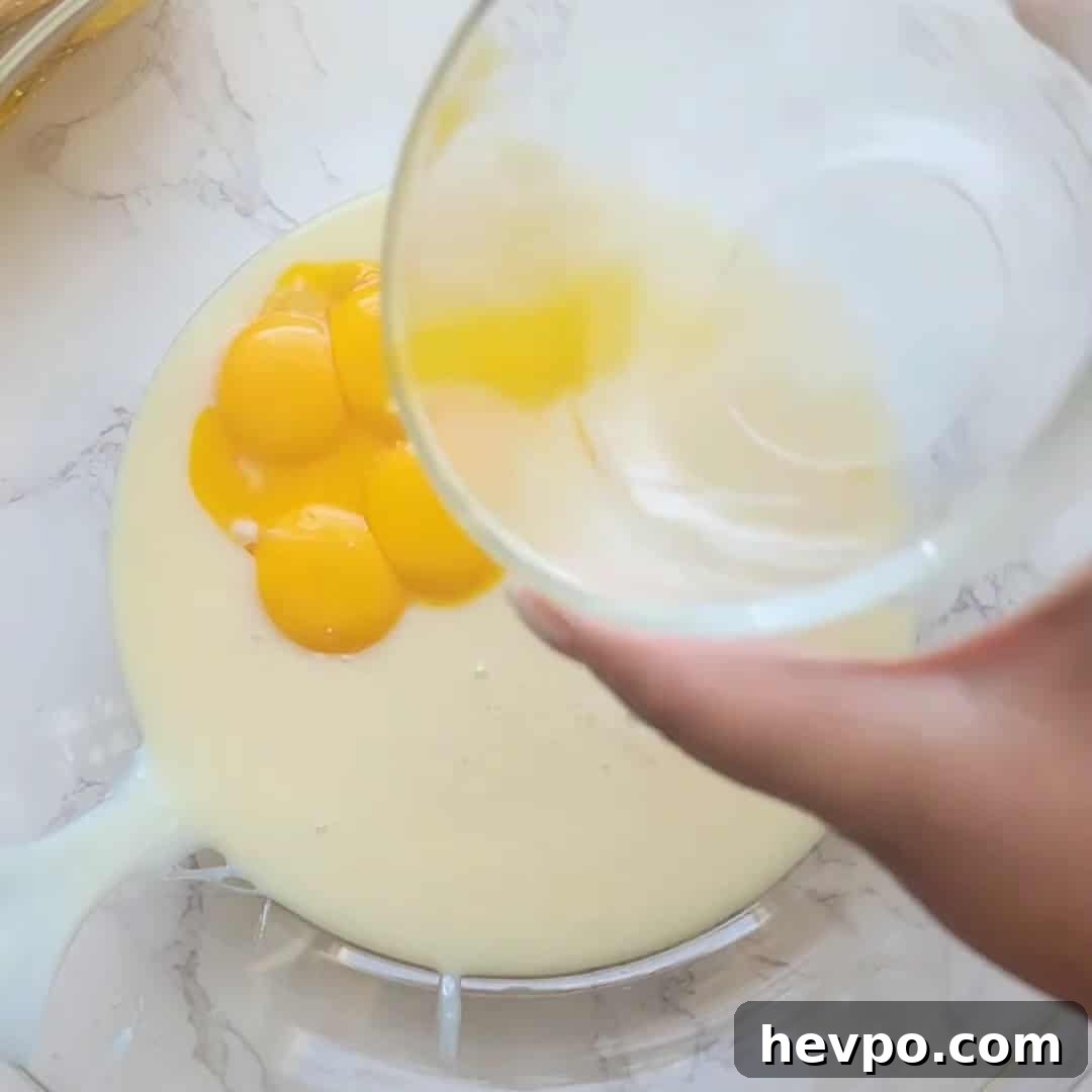 Pouring egg yolks into lemon icebox pie batter.