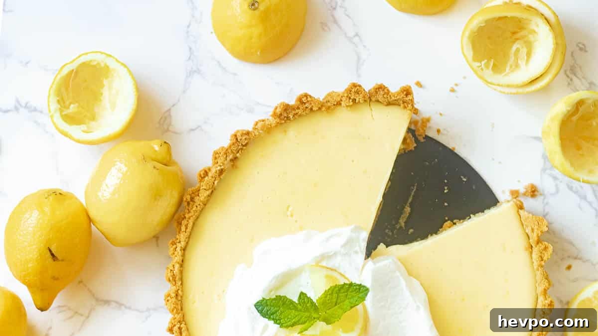 lemon icebox pie with slices cut out and lemons surrounding