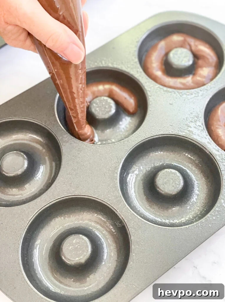 Baked Chocolate Peppermint Donuts Recipe for the Holidays 11 piping into donut pan
