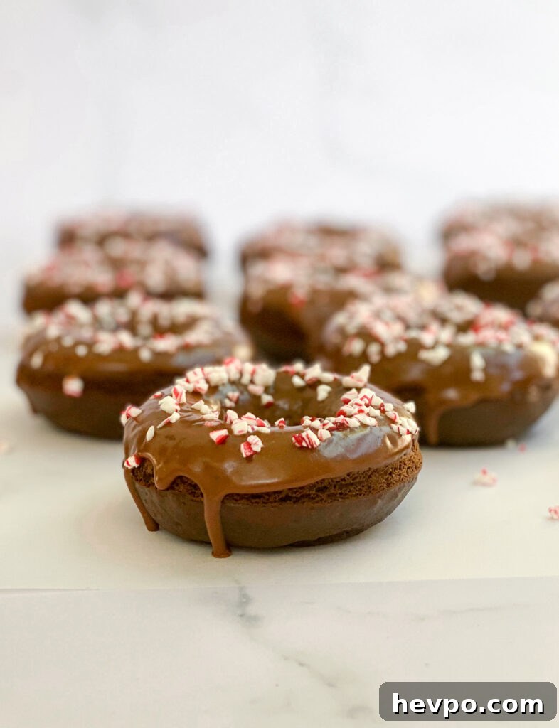Baked Chocolate Peppermint Donuts Recipe for the Holidays 3 side view of baked chocolate peppermint donuts with glaze dripping down