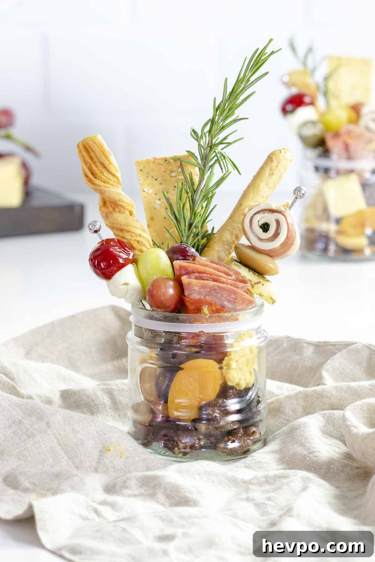 Jarcuterie cup on table filled with charcuterie.
