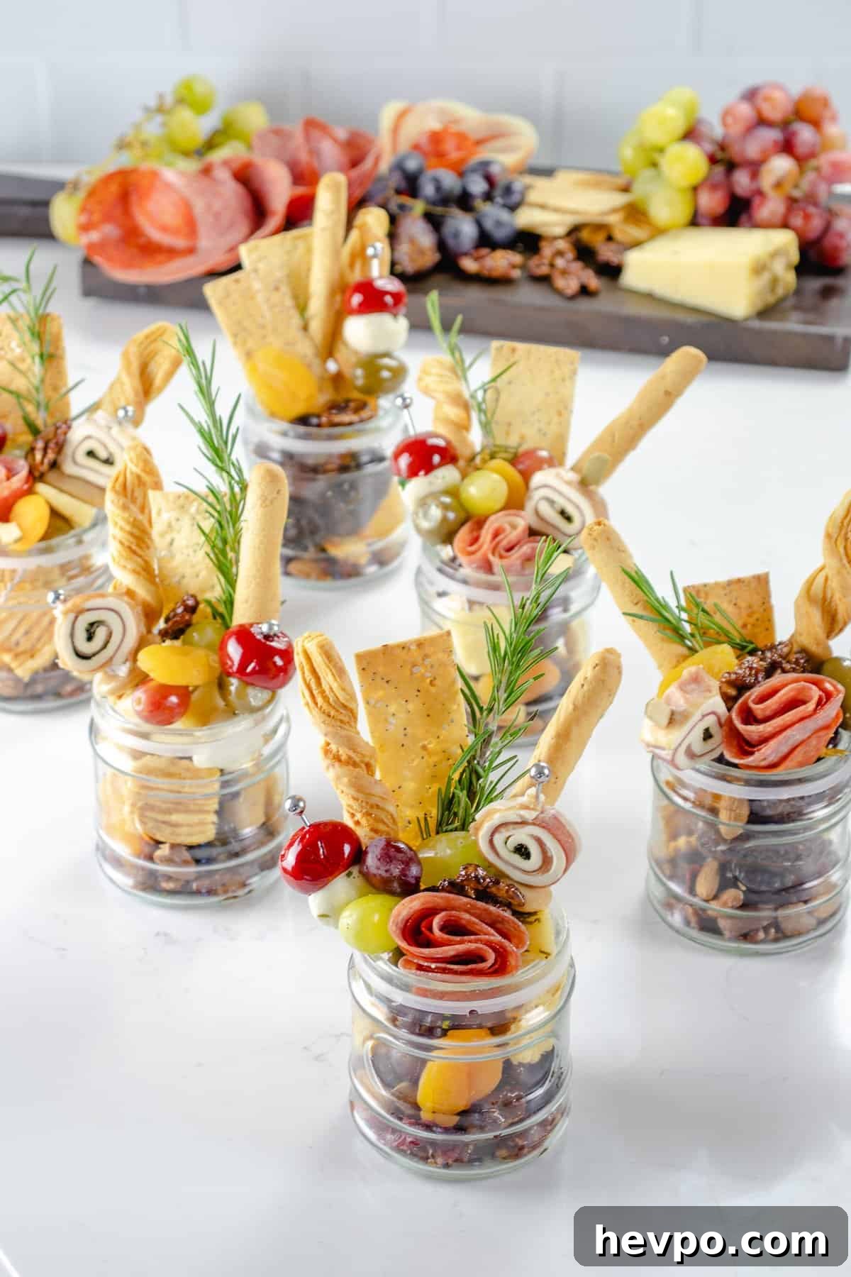 Charcuterie in mason jars on table.