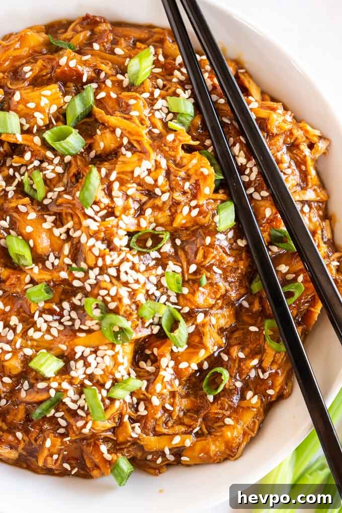Shredded Teriyaki Chicken Made in the Instant Pot 3 A white bowl filled with teriyaki chicken made in the instant pot.