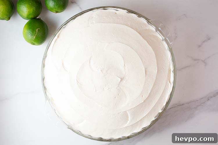 overhead view of keto no bake key lime cheesecake in a glass pie serving dish