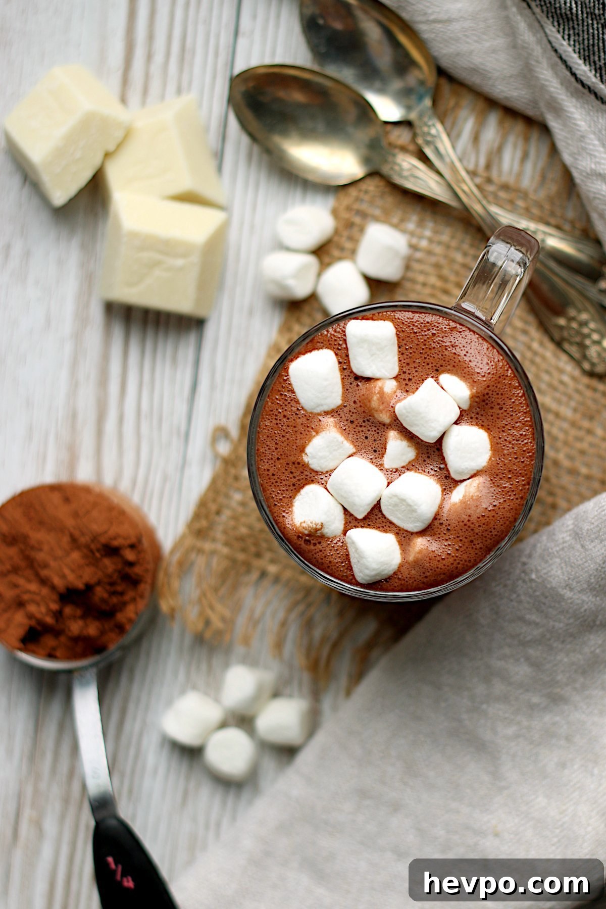Overhead photo of homemade hot chocolate with mini marshmallows in a clear glass mug.