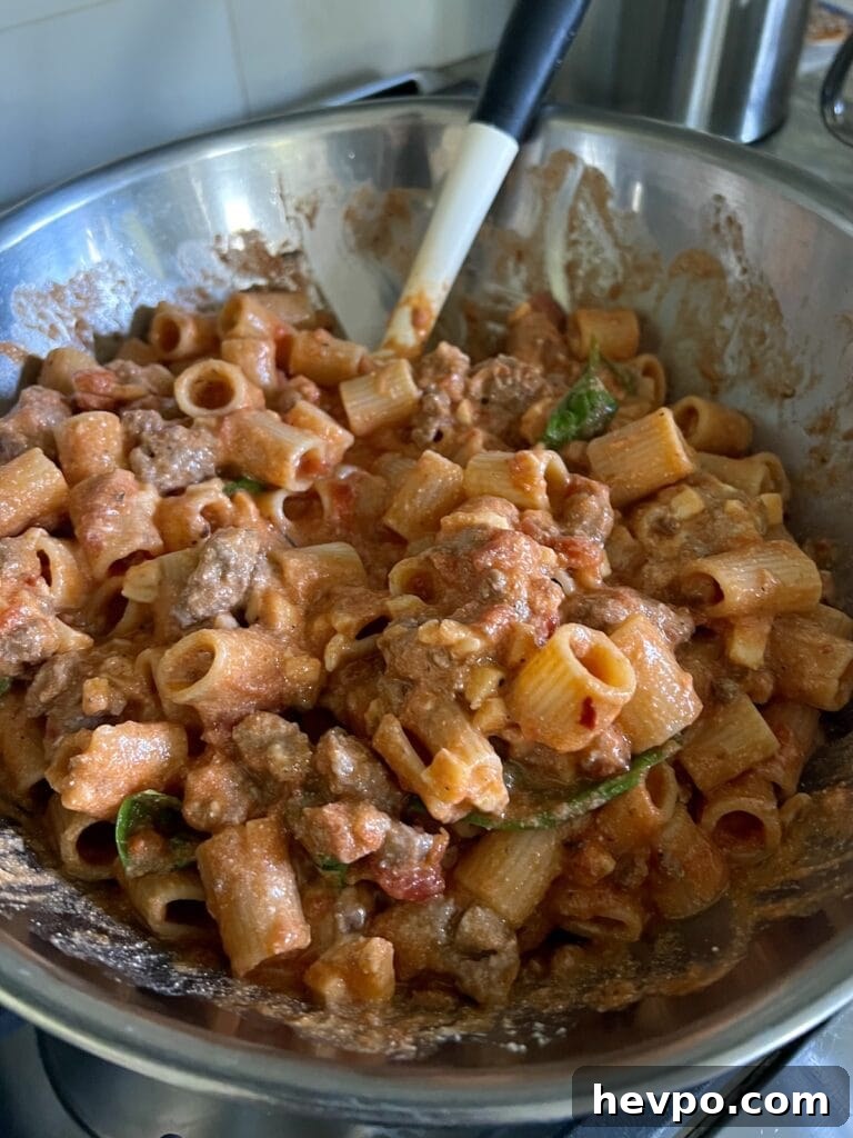Baked Rigatoni al Forno with Sausage and Beef: Rustic Oven Pasta 11 All ingredients for rigatoni and meat sauce mixed together in a large bowl, with spatula.