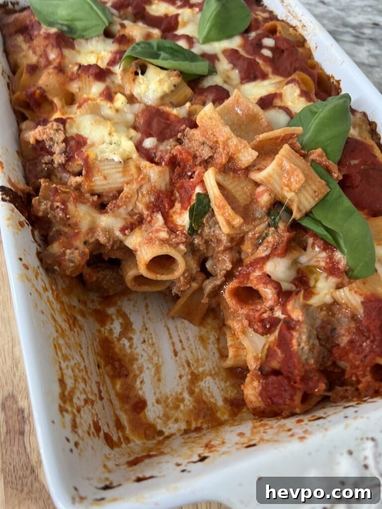 Baked Rigatoni al Forno with Sausage and Beef: Rustic Oven Pasta 19 Baked Rigatoni al forno in baking dish with one slice cut out.