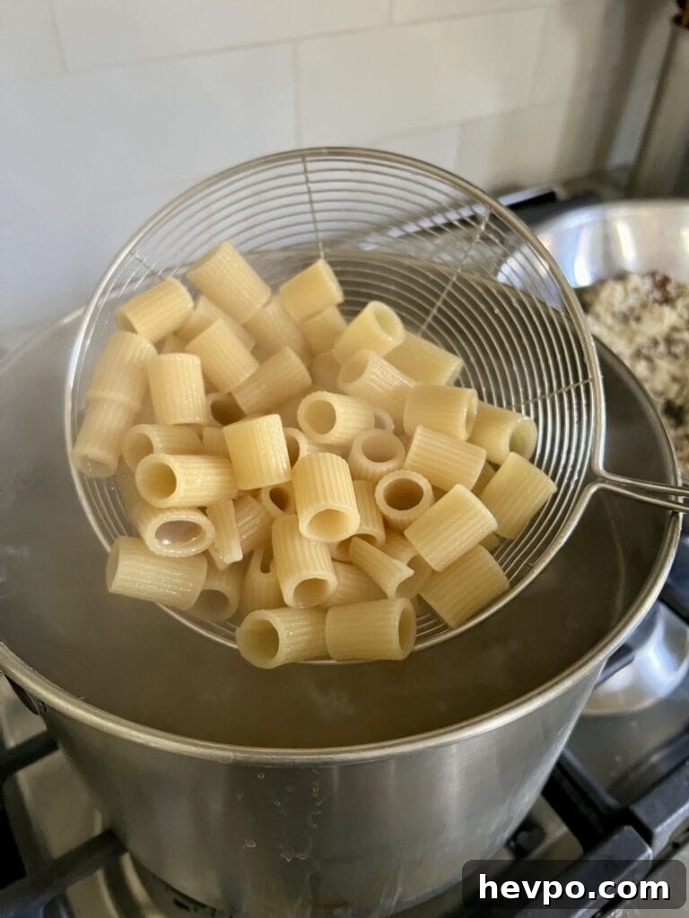 Baked Rigatoni al Forno with Sausage and Beef: Rustic Oven Pasta 7 Cooking the pasta in a large pot of boiling water.