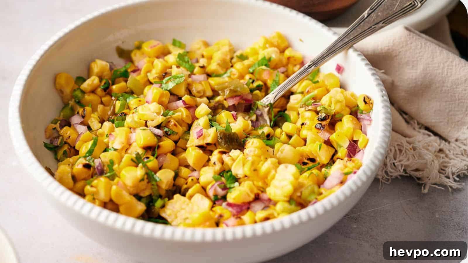 31 Copycat Restaurant Recipes for Delicious Nights In 2 A bowl of freshly made Copycat Chipotle corn salsa with a serving spoon in it.