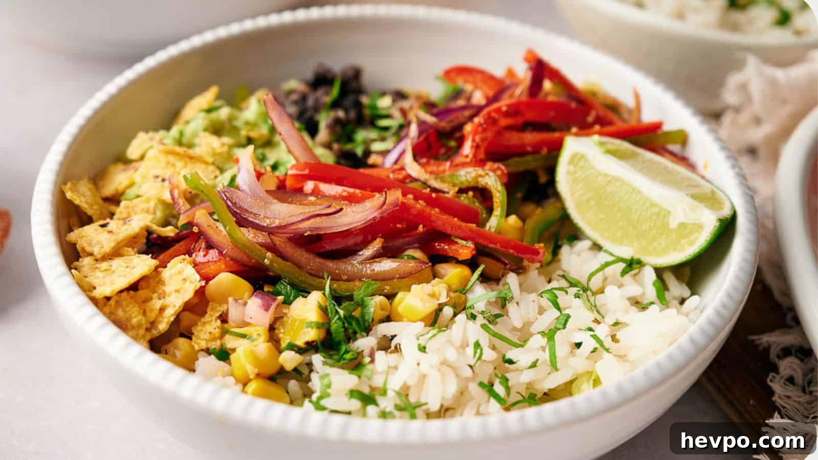 31 Copycat Restaurant Recipes for Delicious Nights In 19 A Copycat Chipotle burrito bowl, filled with rice, fajita veggies, corn salsa, tortilla chips. and topped with a lime wedge.