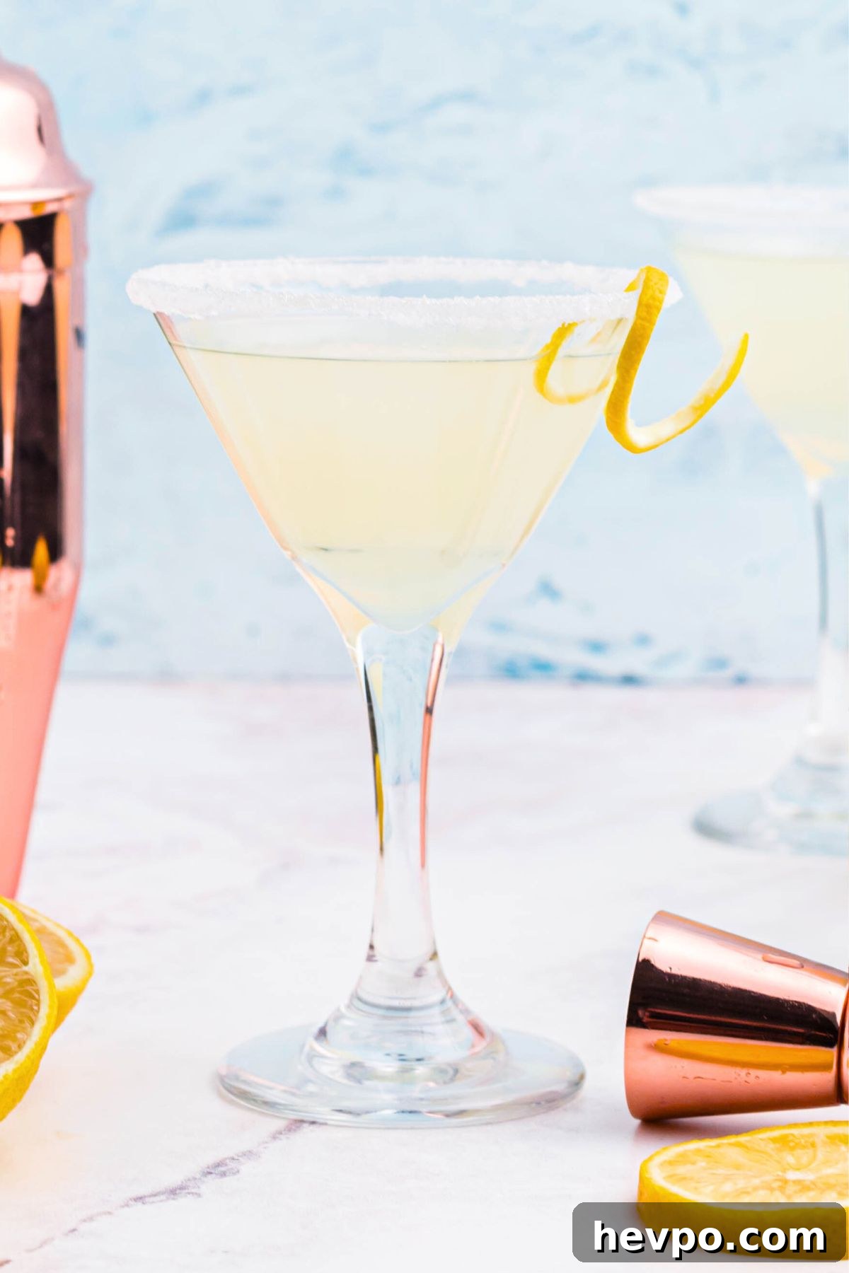 Citrus Lemon Drop Martini Recipe — Zesty Cocktail Guide 2 Light yellow lemon drop martini in a glass with a lemon curl garnish.