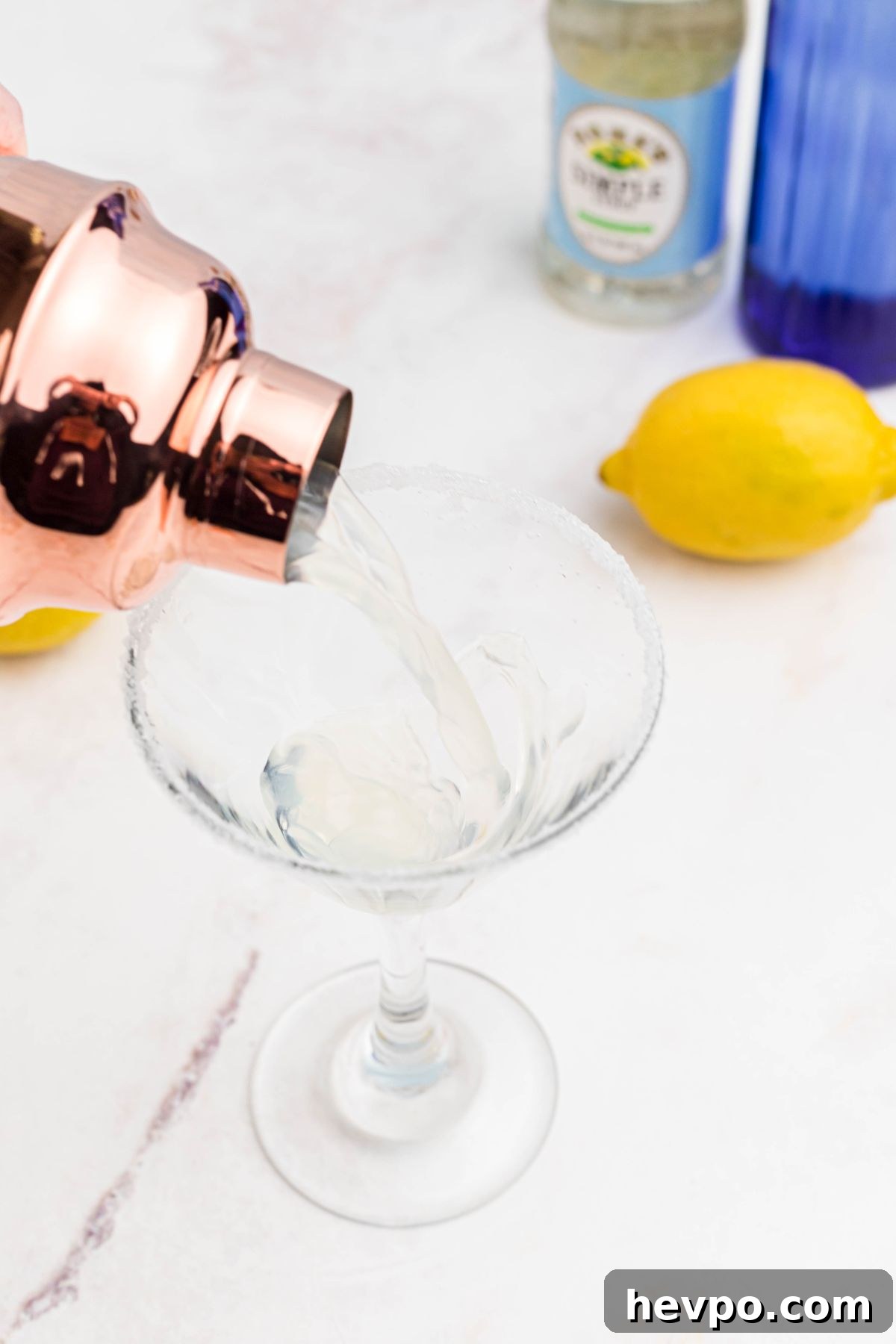 Citrus Lemon Drop Martini Recipe — Zesty Cocktail Guide 5 Vodka and simply syrup mixture being poured in a martini glass.