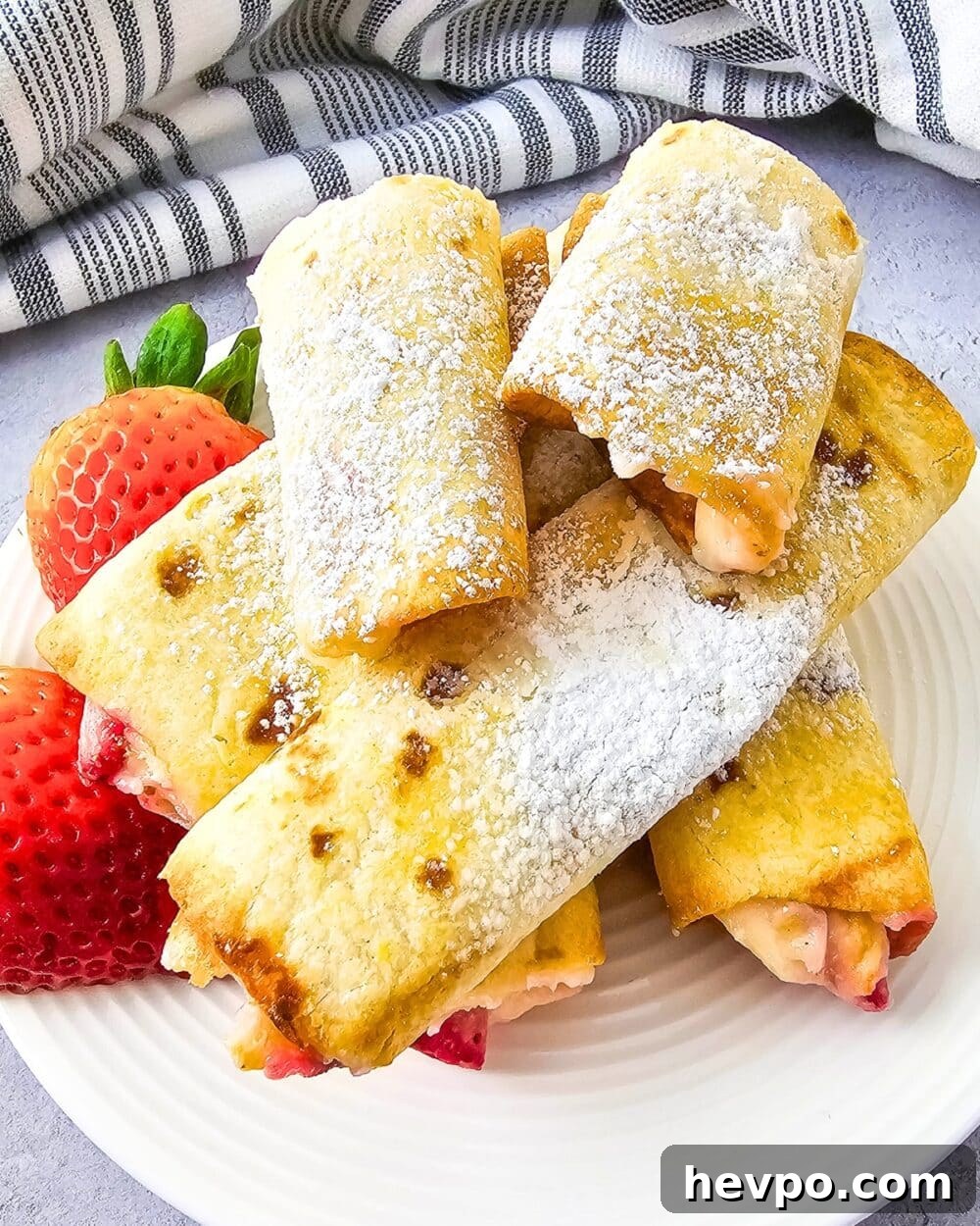 Keto Air Fryer Strawberry Cheesecake Roll Ups on a plate with strawberries