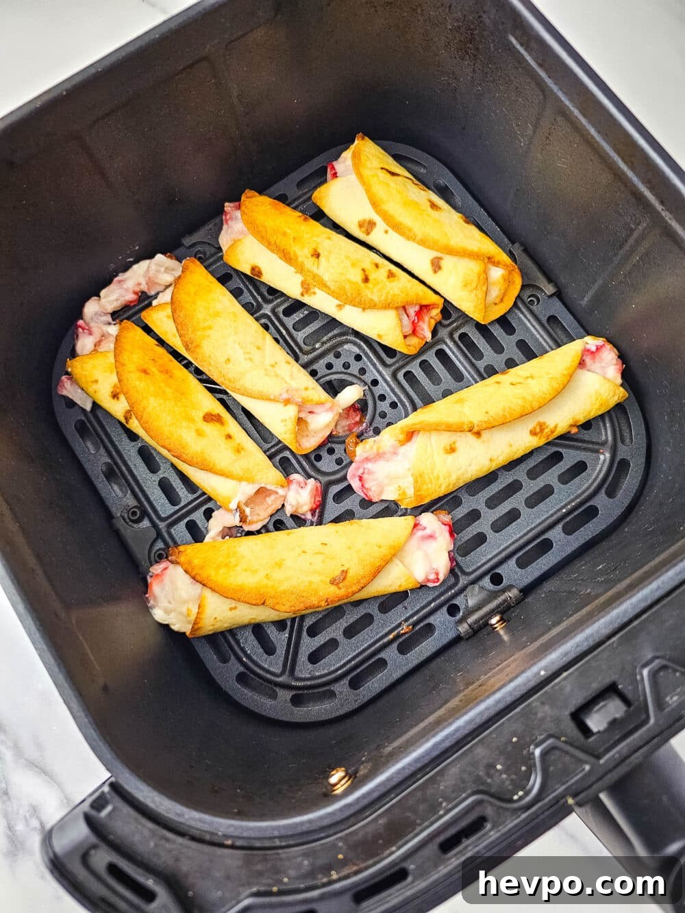 fresh cooked strawberry roll-ups in air fryer basket