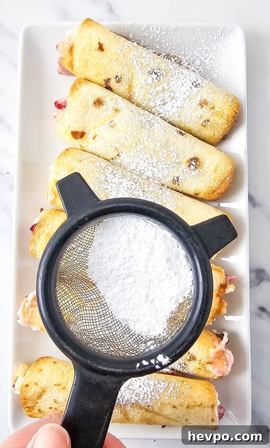 dusting strawberry roll-ups with powdered sweetener
