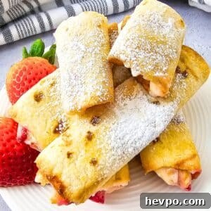 Keto Air Fryer Strawberry Cheesecake Roll Ups on a plate with strawberries
