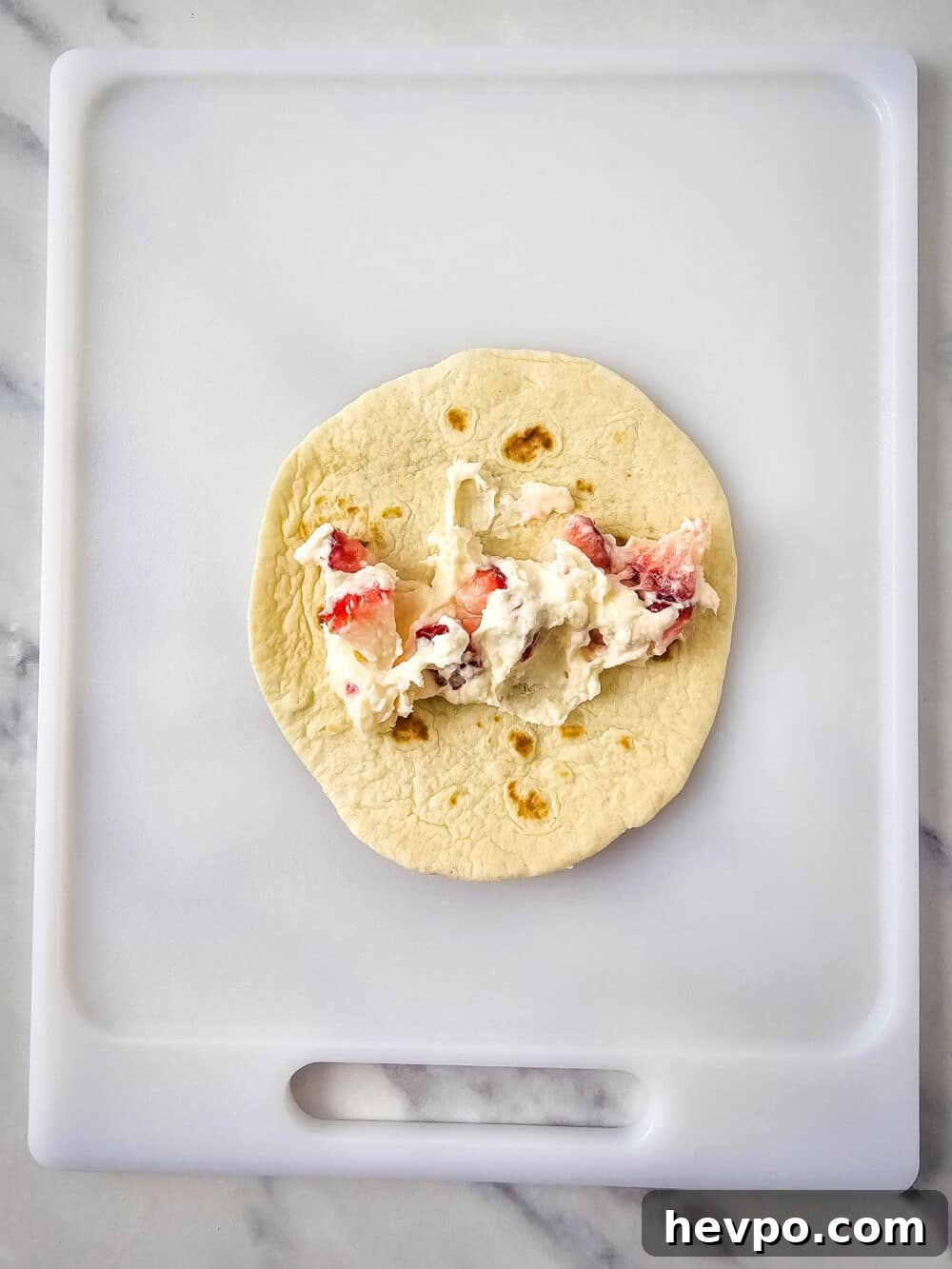 open face tortilla with strawberry cheesecake filling, showing how to fill