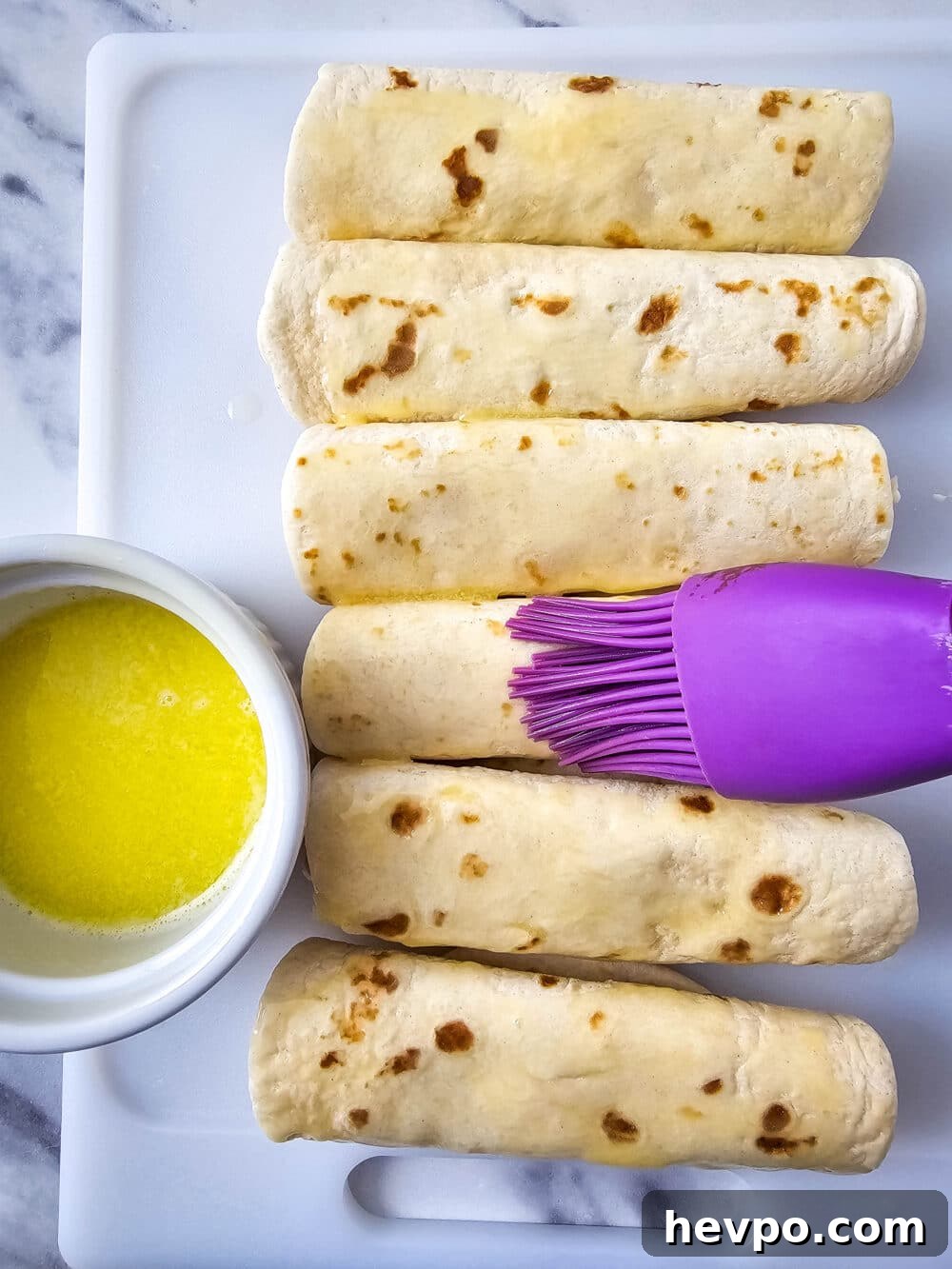brushing tortillas with butter
