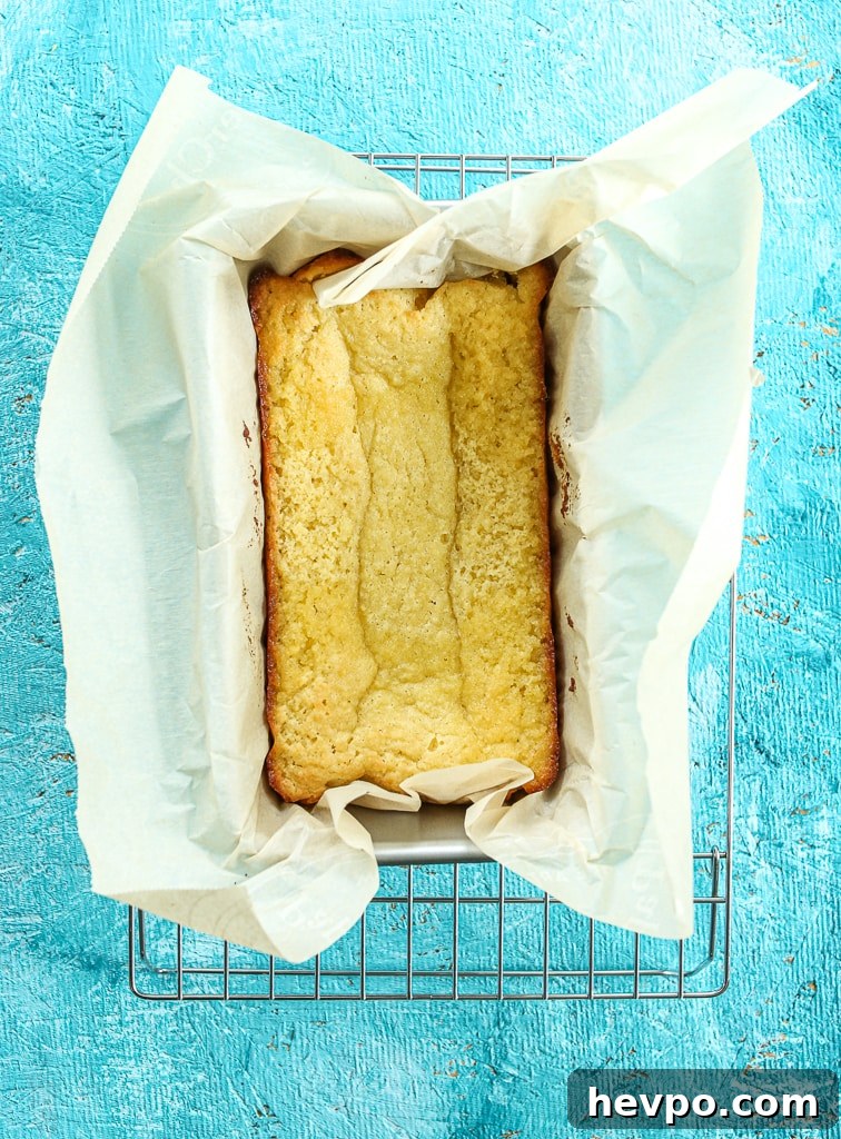 Keto Gluten-Free Sugar-Free Lemon Loaf Cake Recipe 7 cooked cake cooling on a wire baking rack in the pan with parchment paper