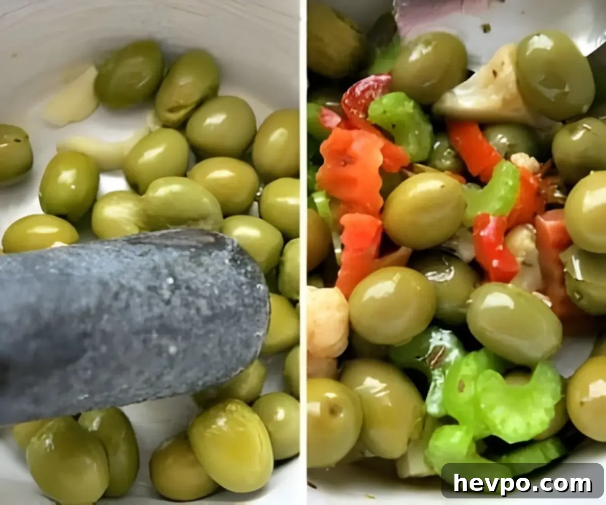 Green olives being cracked with a mallet and then mixed with vegetables in a bowl.