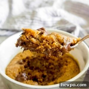 A spoon of Gluten-free Mug Cookie being lifted out of a ramekin.
