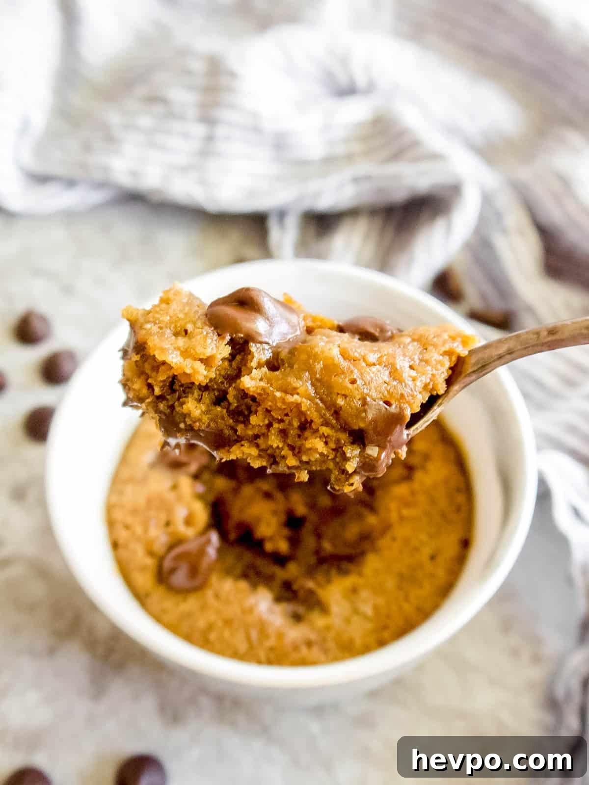 A bite of a paleo mug cookie on a spoon.