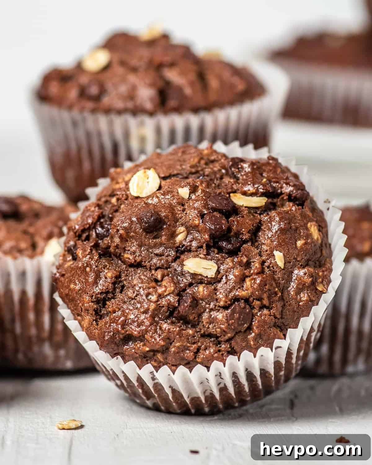 Decadent Chocolate Oatmeal Muffins with Chocolate Chips 2 a chocolate oatmeal muffin tilted on its side to show the muffin top texture.