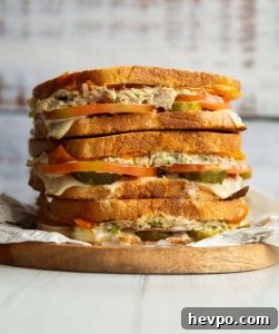 Tuna Melt 3 tuna melts stacked on each other on small wooden board