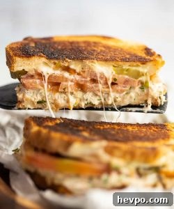 Tuna Melt black spatula lifting half a tuna melt up with cheese pull