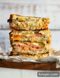 Tuna Melt 4 tuna melt halves stacked on each other on small wooden board