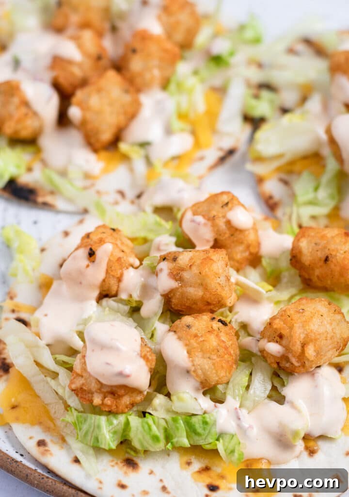 Spicy Potato Soft Tacos Recipe for Flavorful Weeknight Meals 3 A tortilla with melted cheese, shredded lettuce, tator tots and a creamy chipotle sauce