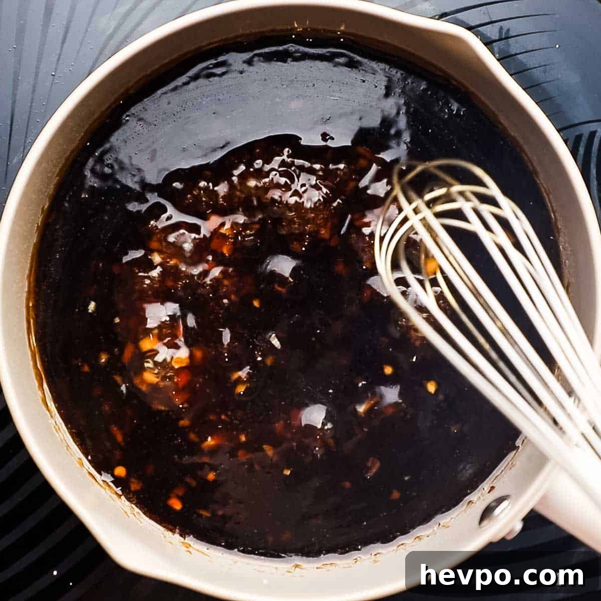 whisking pineapple teriyaki sauce over heat
