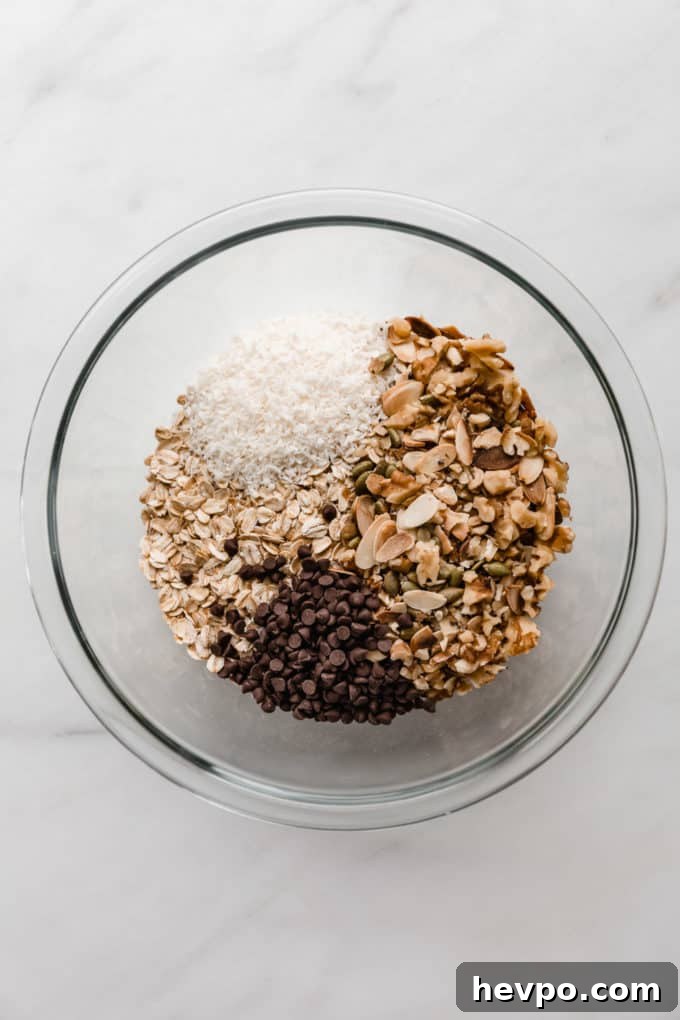 Homemade Muesli Bars Recipe for Energy and Crunch 3 oats, nuts, coconut and chocolate chips in a mixing bowl