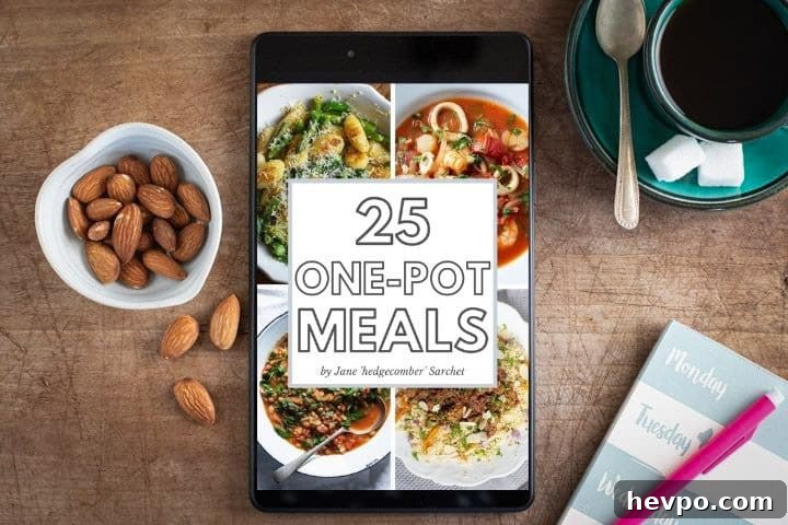 wooden surface with small bowl of almonds, green cup and saucer of black coffee, meal planning notebooks and ipad with one pot meals ebook open