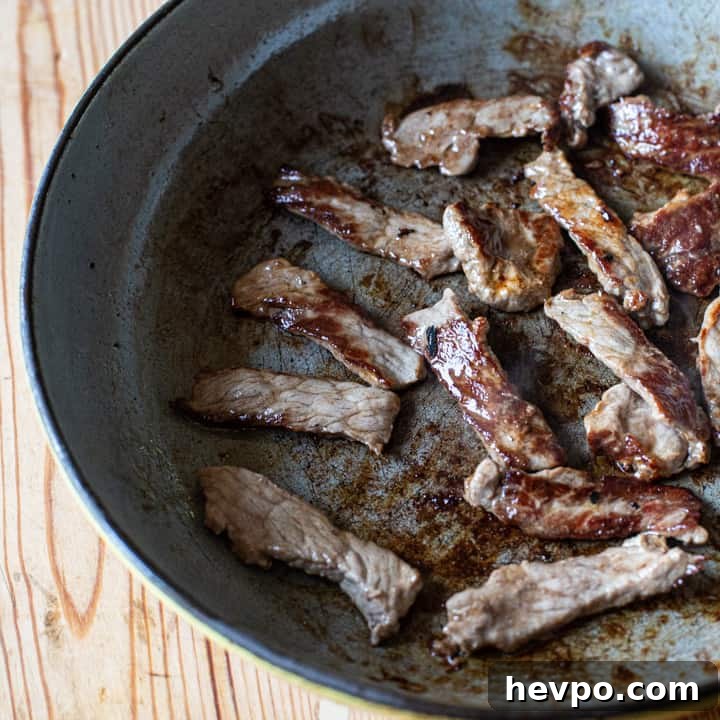 inside shot of a frying pan with strips of caramelised sirloin steak