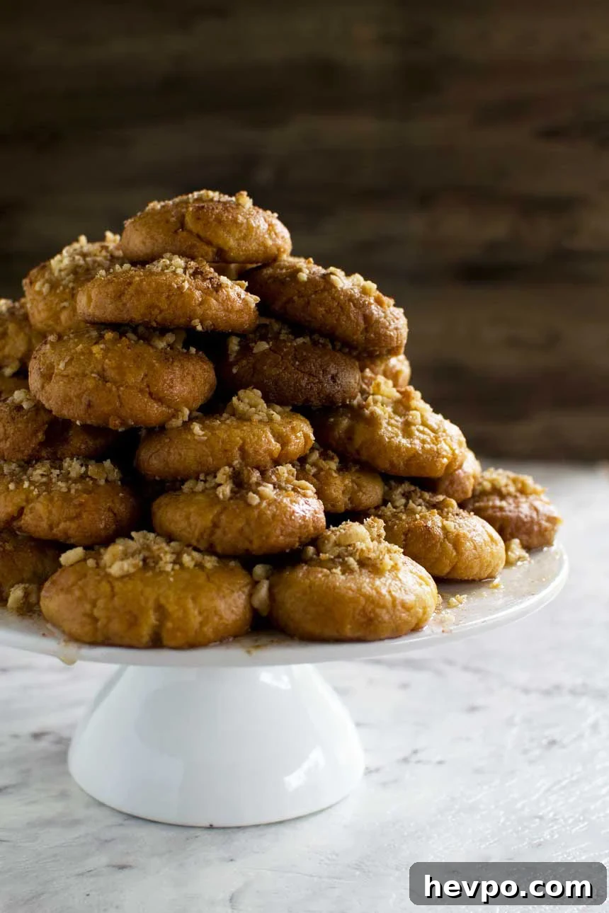 Melomakarona: Traditional Greek Christmas Honey Cookies Recipe 5 A pyramid of Greek Christmas honey cookies on a white cake stand