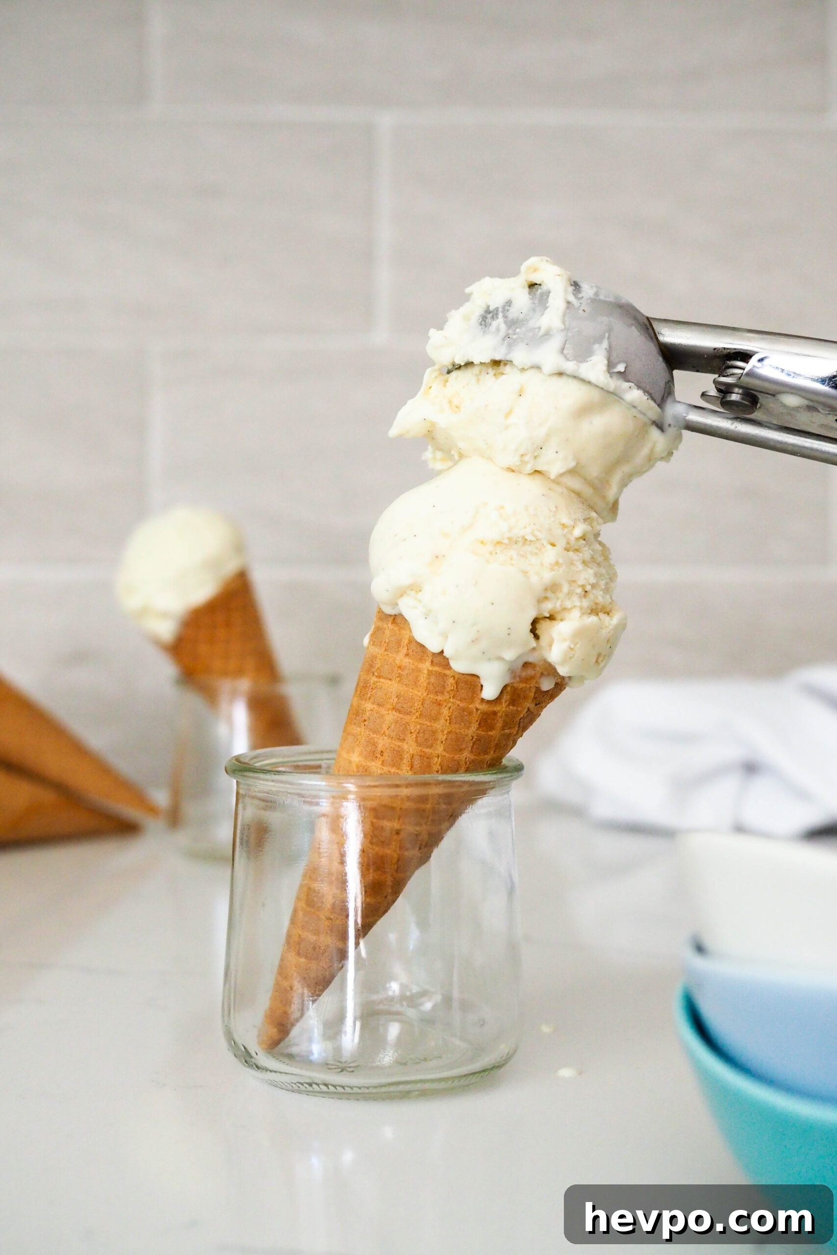 Homemade French Vanilla Ice Cream Recipe – Creamy & Classic 2 An ice cream scoop adds a second scoop to a sugar cone.