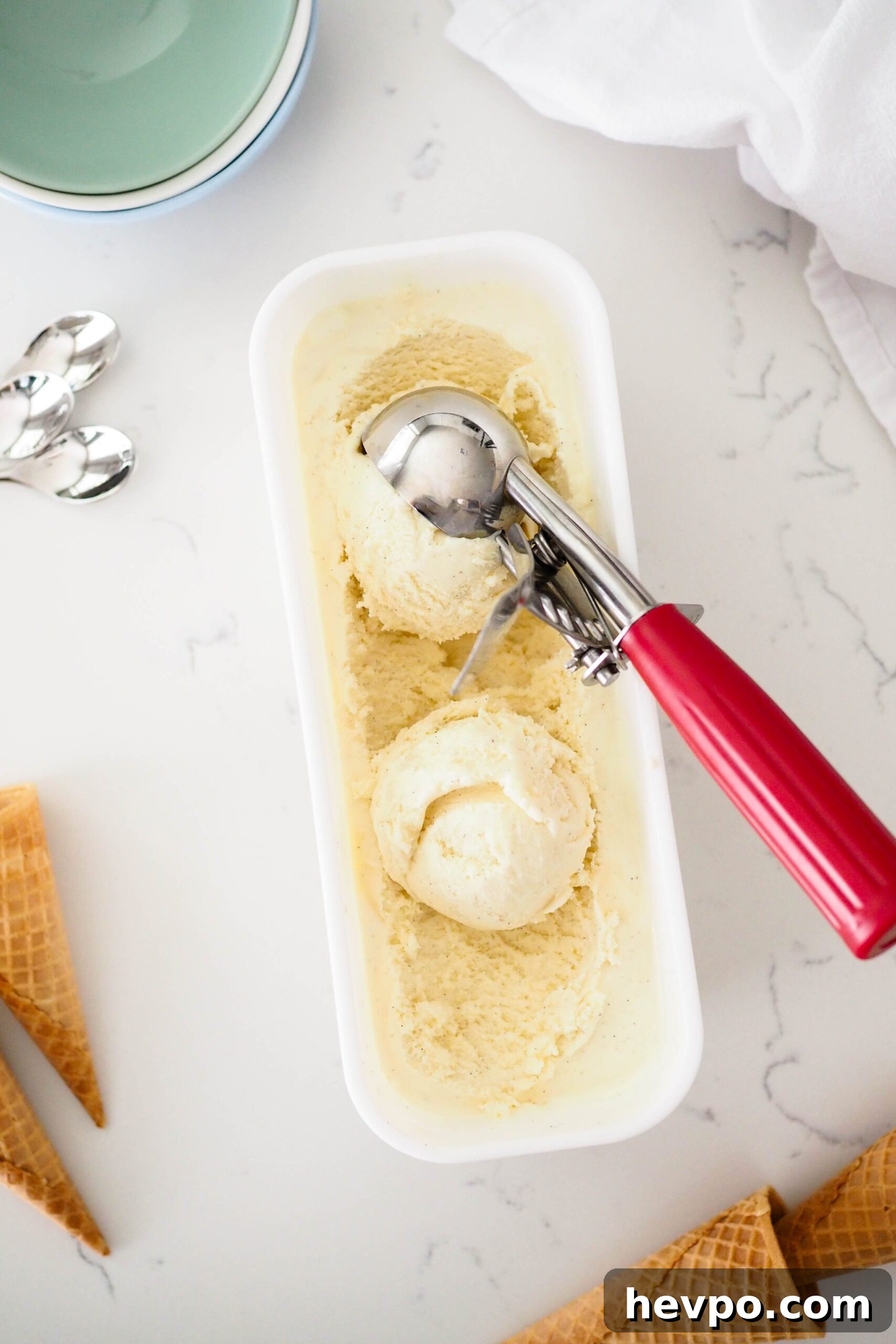Homemade French Vanilla Ice Cream Recipe – Creamy & Classic 16 An overhead view of an ice cream scoop getting a scoop of French vanilla ice cream.