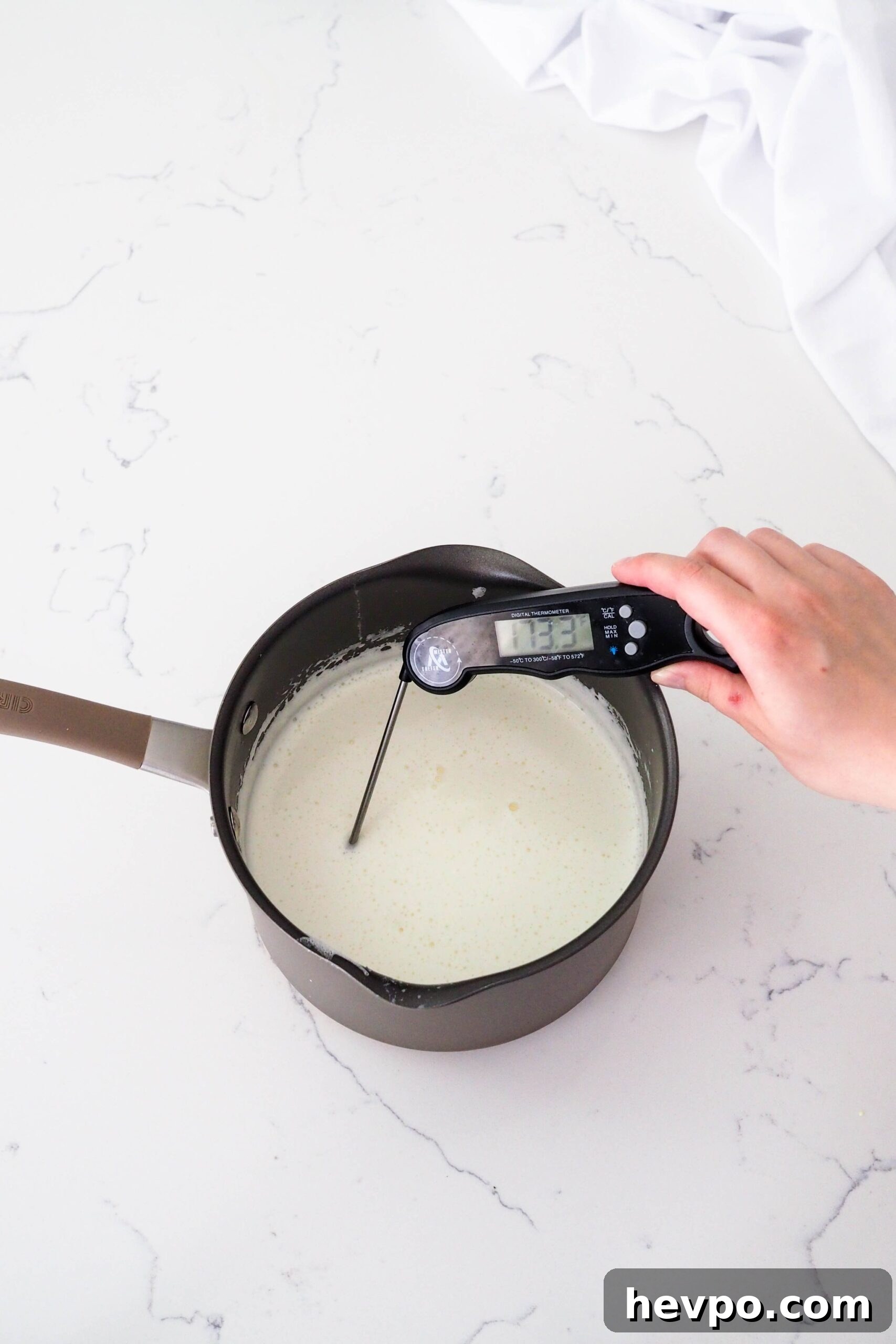 Homemade French Vanilla Ice Cream Recipe – Creamy & Classic 8 A hand sticks an instant read thermometer into a pot of custard ice cream.