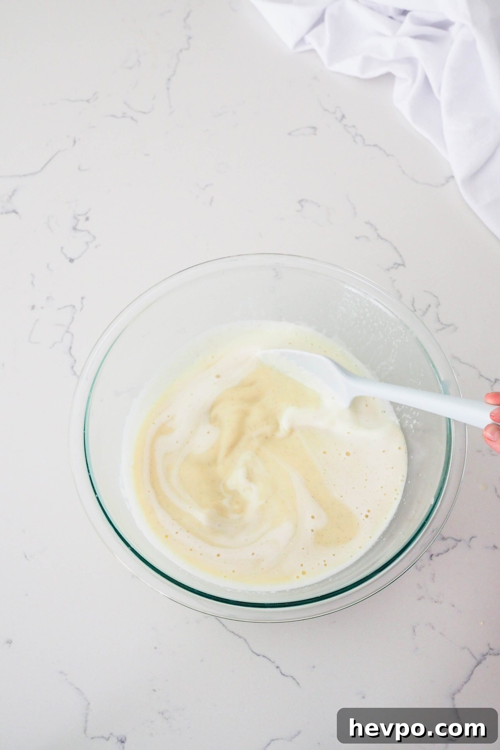 Homemade French Vanilla Ice Cream Recipe – Creamy & Classic 10 A spatula stirs vanilla bean paste into custard.