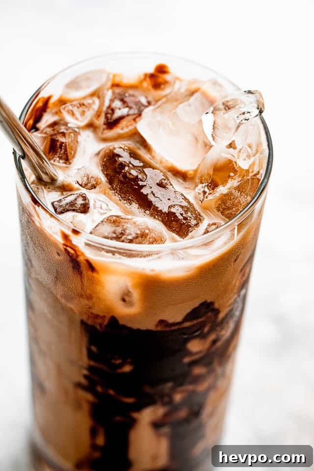 ice floating on top of coffee in a drinking glass