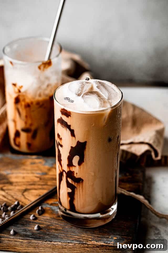 top side view of two drinking glasses filled with iced coffee and set on top of brown board