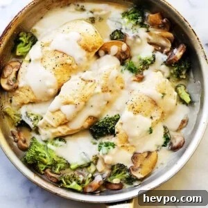 Creamy chicken Alfredo with broccoli in a skillet.