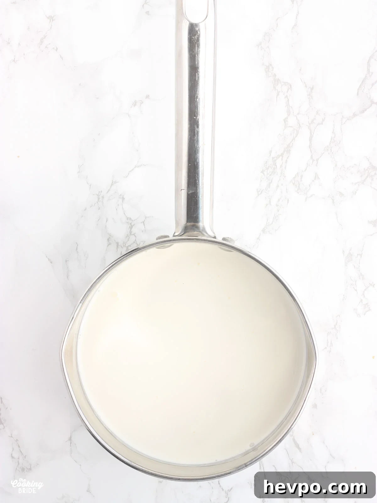milk and heavy cream warming in a steel saucepan