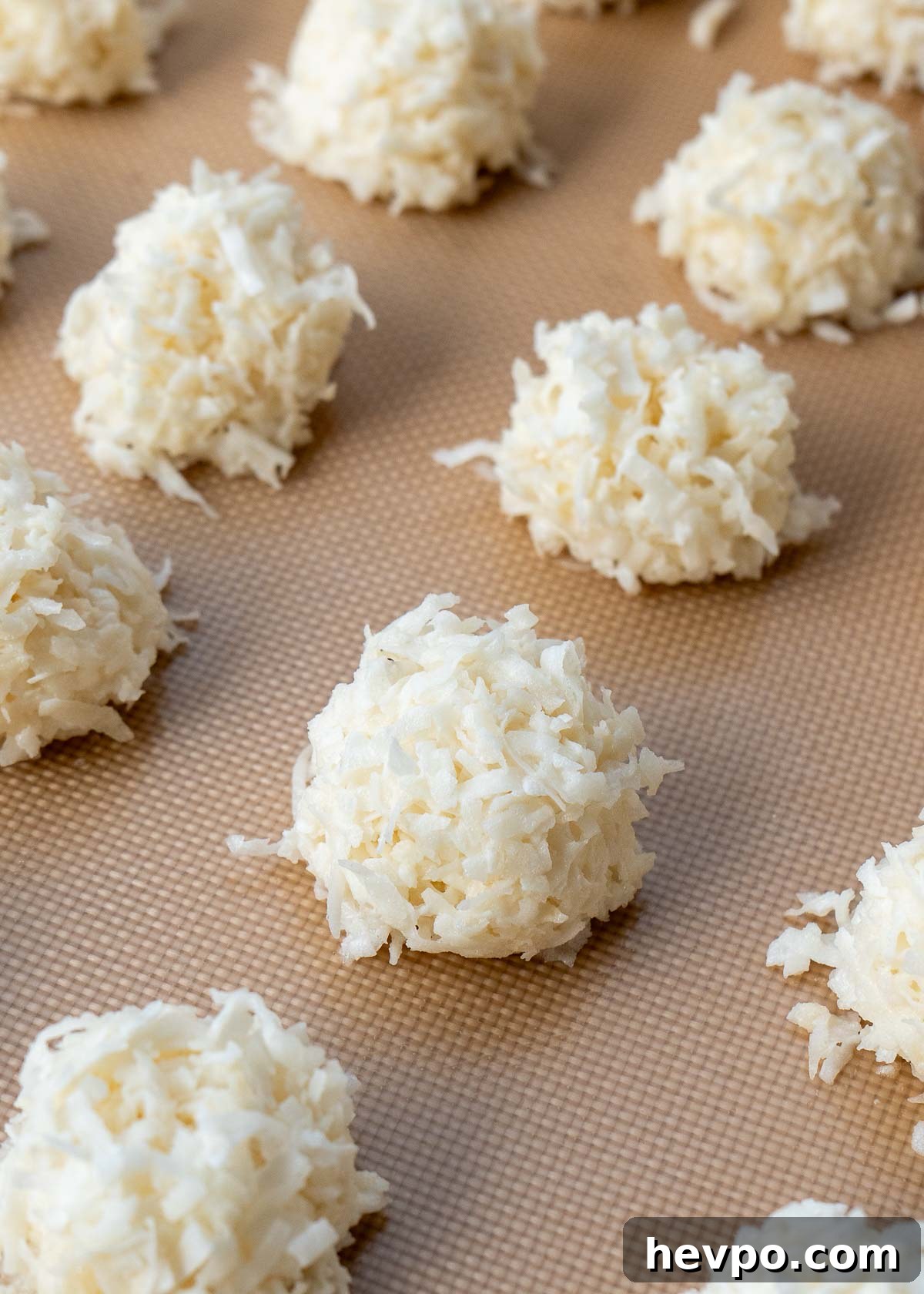 macaroons being shaped and added to cookie sheet