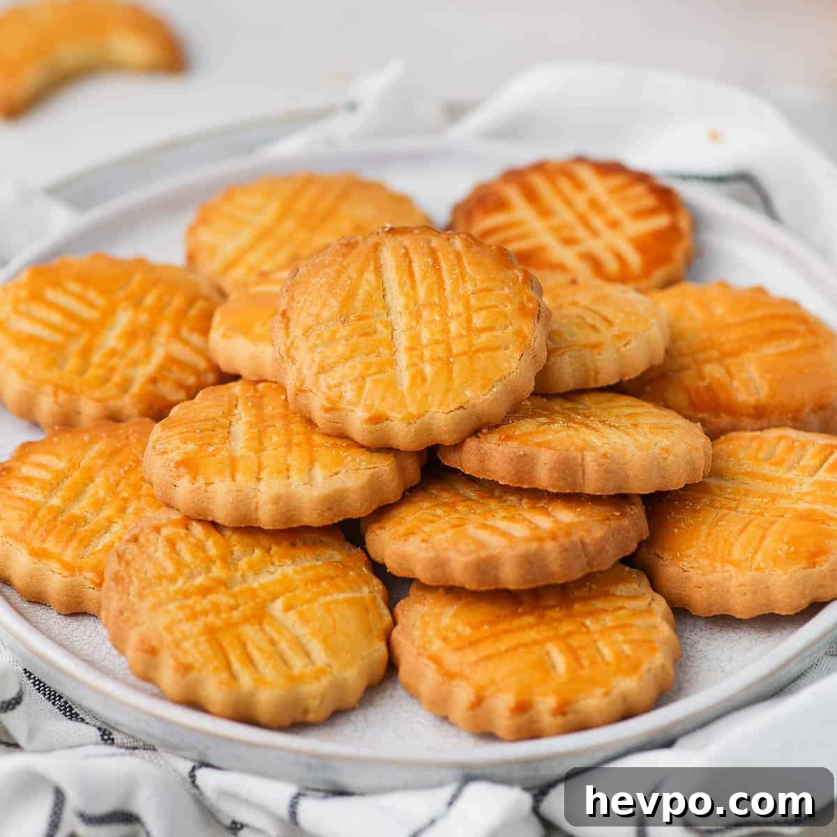 Classic French Sablés Bretons: Irresistible Salted Butter Cookies 2 Sables Bretons Cookies stacked on a small white plate.