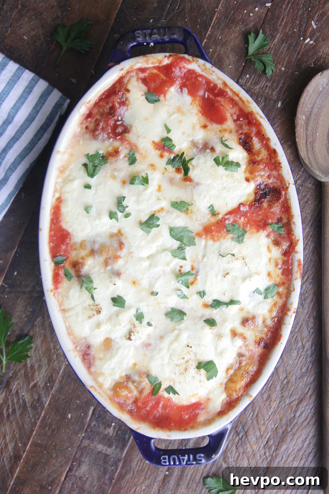 Overhead photo of Gnocchi Lasagna in a blue baking dish with melted cheese on top
